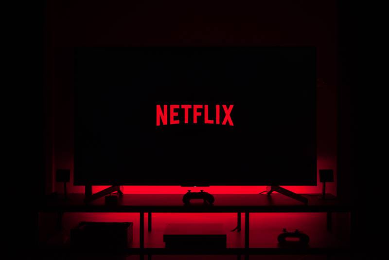 Televisão em sala escura exibindo logo da Netflix