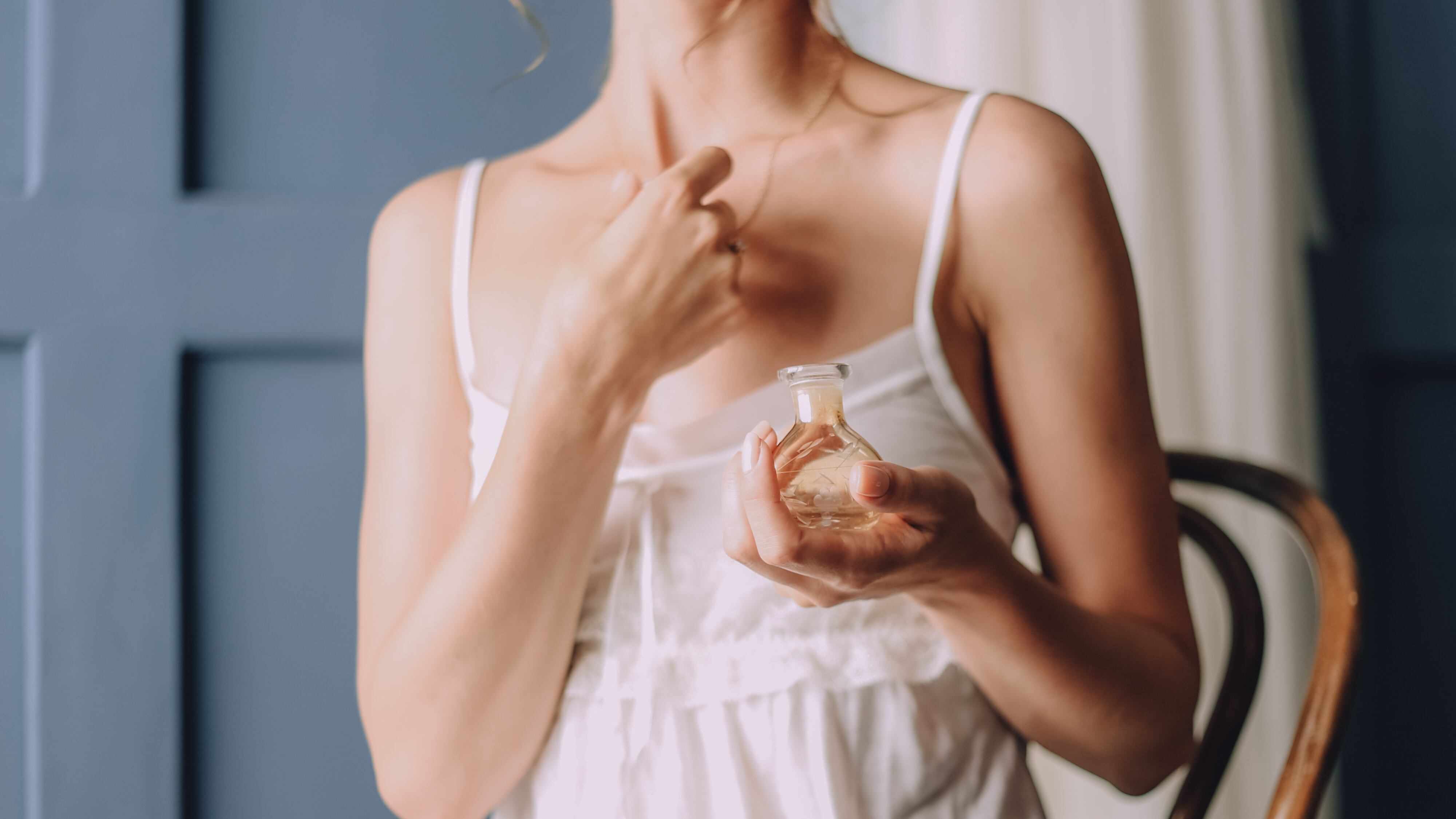 Mulher com roupas frescas segurando perfume