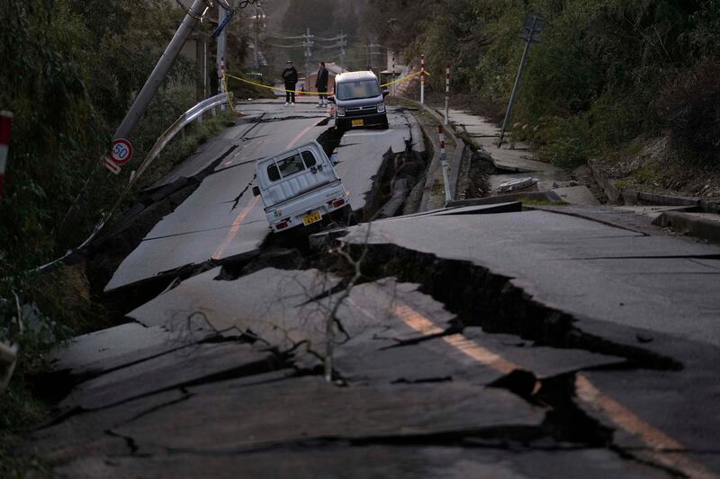 Los transeúntes observan los daños en algún lugar cerca de la ciudad de Noto, en la península de Noto frente al Mar de Japón, al noroeste de Tokio, el martes 2 de enero de 2024, tras el mortal terremoto del lunes. Una serie de potentes terremotos que azotaron el oeste de Japón han dañado miles de edificios, vehículos y barcos. Las autoridades advirtieron que podrían producirse más terremotos en el futuro. (Foto AP/Hiro Komae)