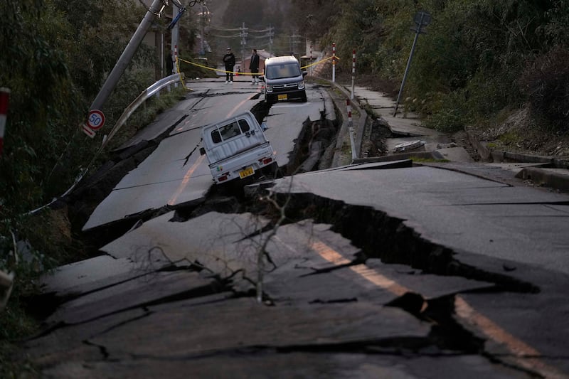 Los transeúntes observan los daños en algún lugar cerca de la ciudad de Noto, en la península de Noto frente al Mar de Japón, al noroeste de Tokio, el martes 2 de enero de 2024, tras el mortal terremoto del lunes. Una serie de potentes terremotos que azotaron el oeste de Japón han dañado miles de edificios, vehículos y barcos. Las autoridades advirtieron que podrían producirse más terremotos en el futuro. (Foto AP/Hiro Komae)