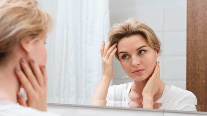 Mujer mirando en el espejo desde atrás