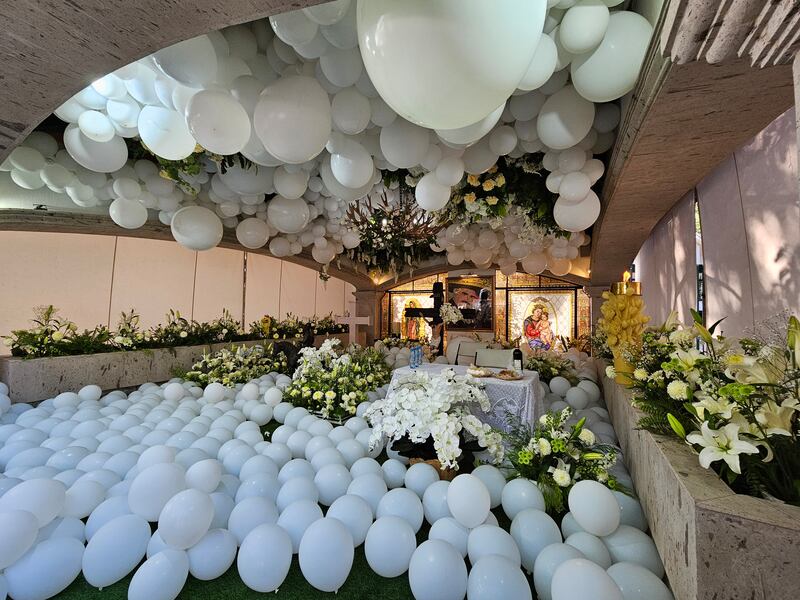 La tumba se cubrió de globos blancos.