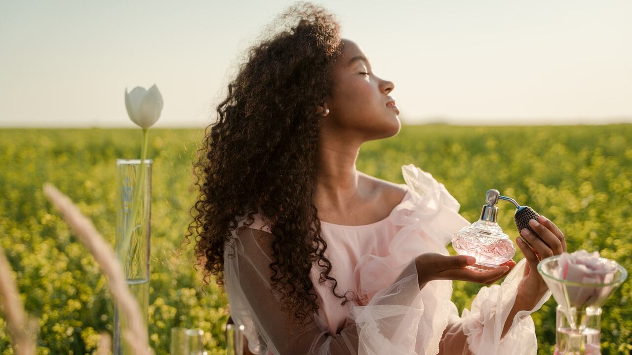 Mujer perfumándose al aire libre