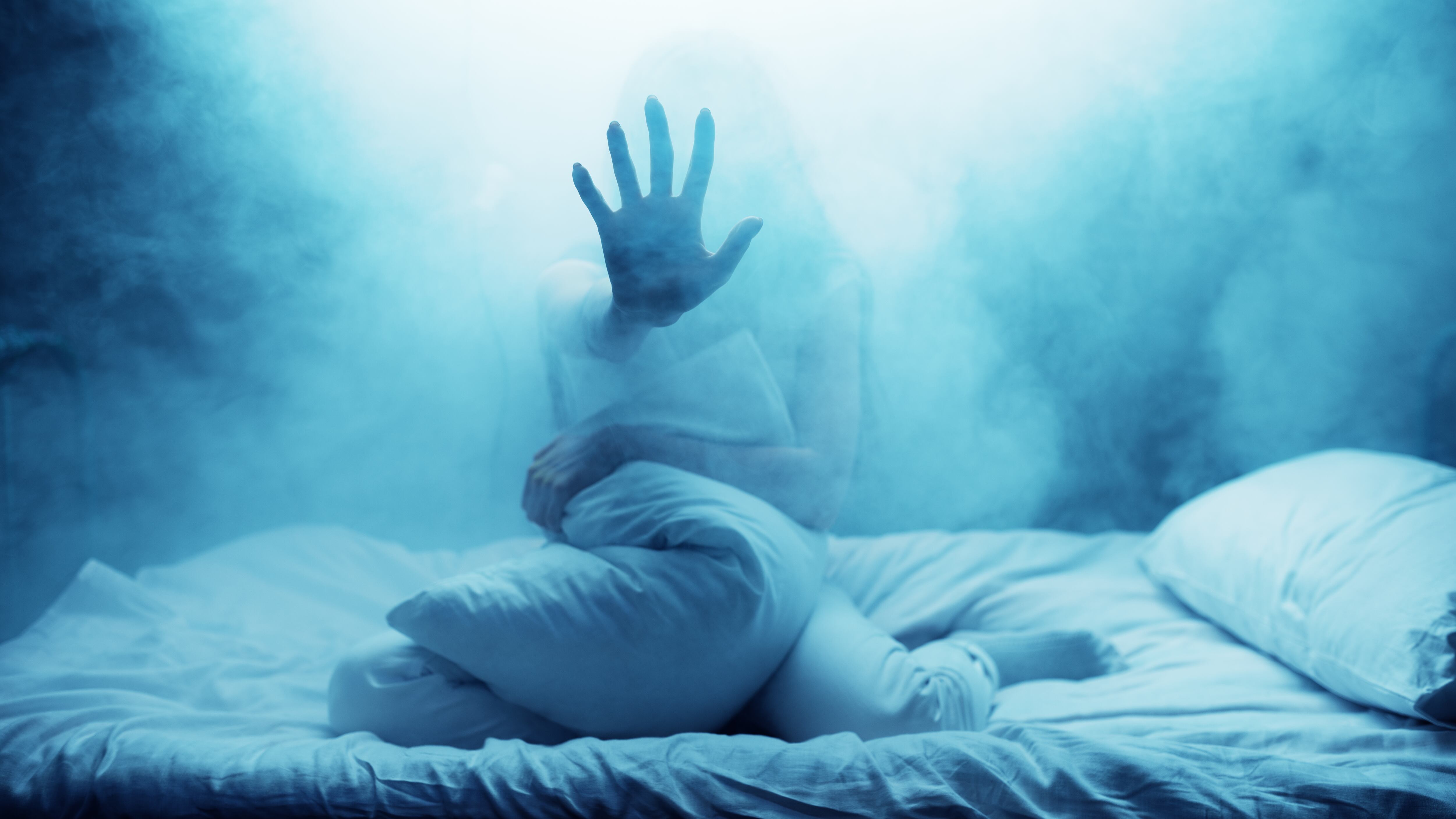 Mujer muestra la mano en la cama