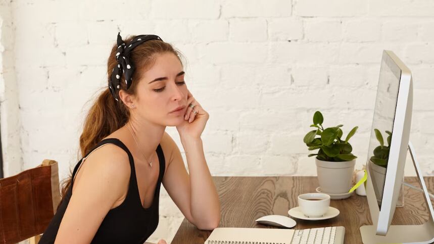 La talentosa joven diseñadora piensa en el diseño de un nuevo café trabajando por cuenta propia en casa. Atractiva joven caucásica con emoción pensativa en un rostro, mirando pensativo en el lugar de trabajo