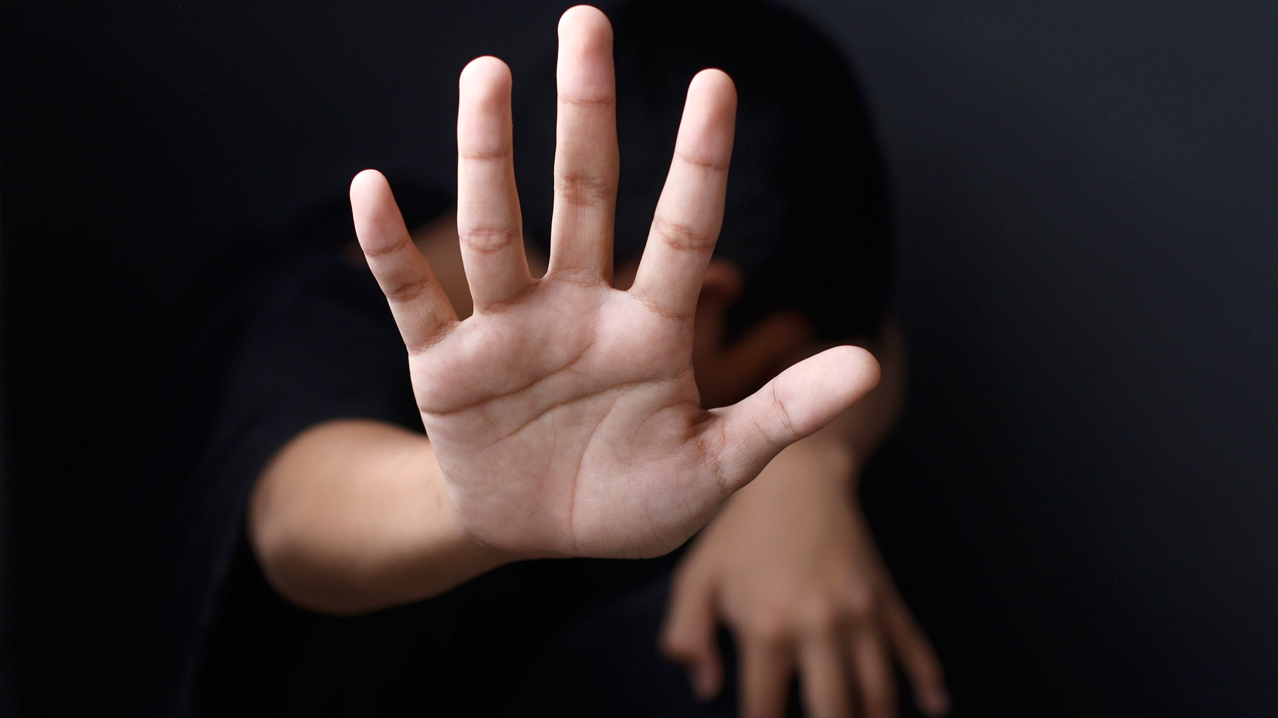 Primer plano de la mano de un niño haciendo el gesto de parar.