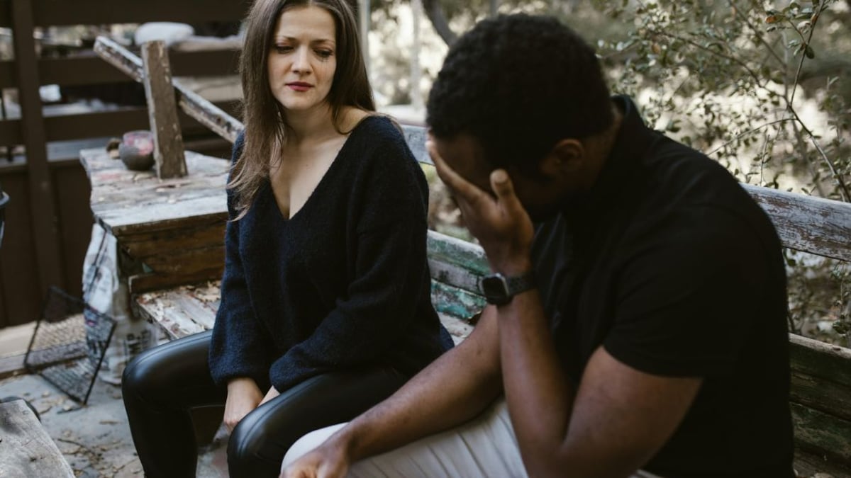 Un hombre llorando frente a una mujer