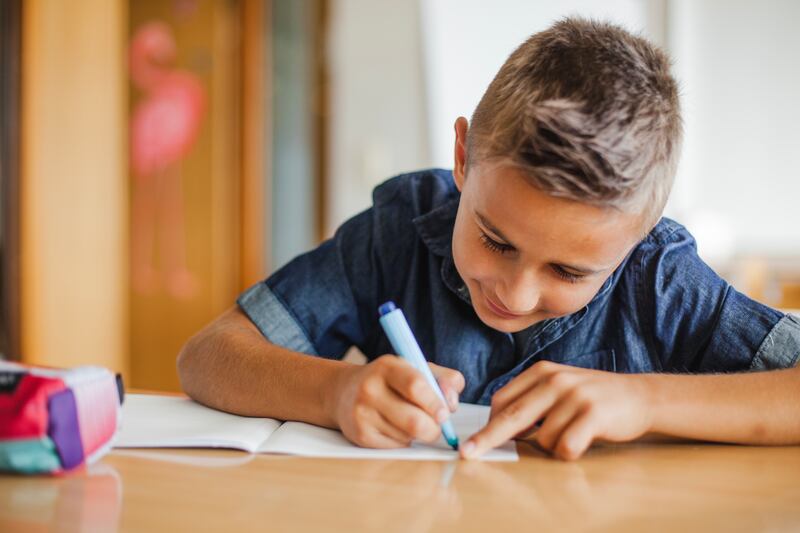 Niño escribiendo a mano