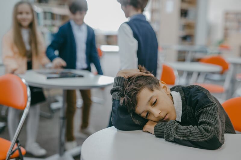 Na escola, criança está longe do grupo de colegas de classe porque sofre bullying